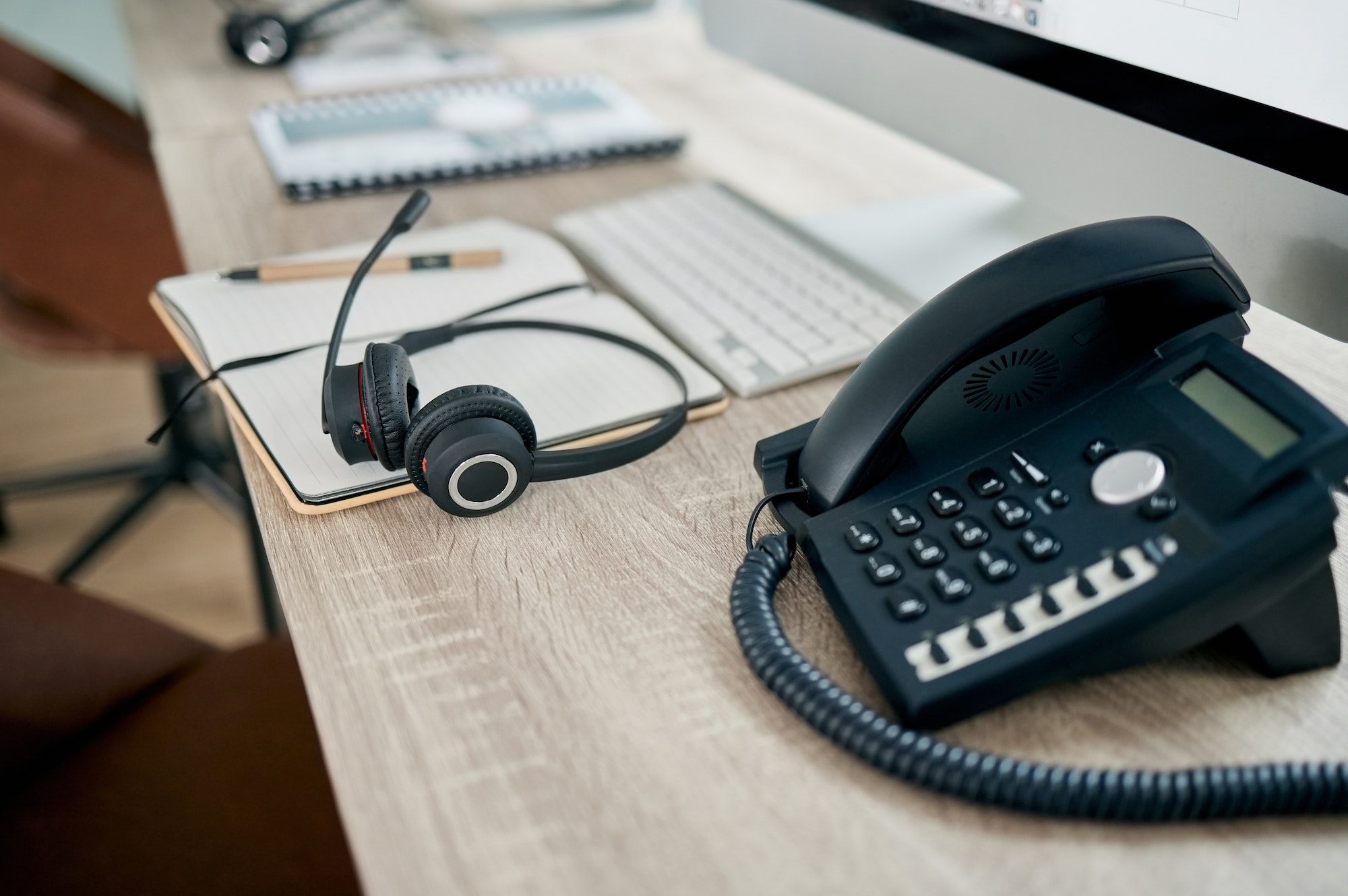 Telemarketing office, phone and VOIP on desk for communication, contact us and consulting by comput