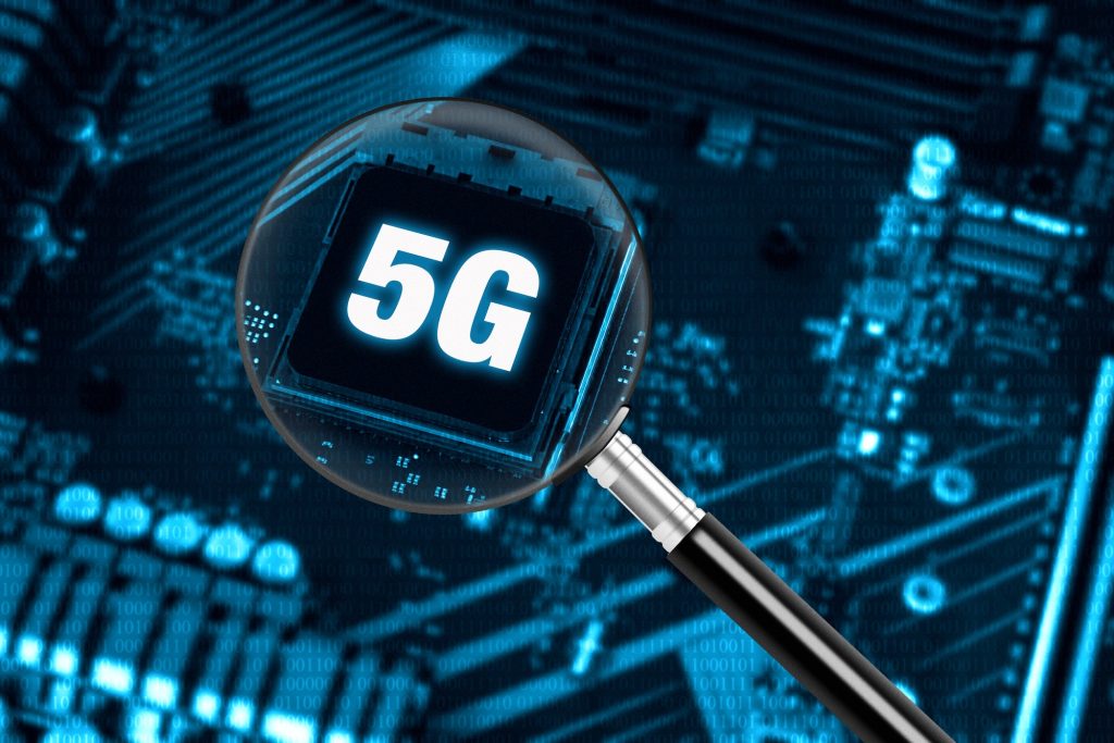 Concept of high-speed 5G internet network technology with magnifying glass on modern circuit board