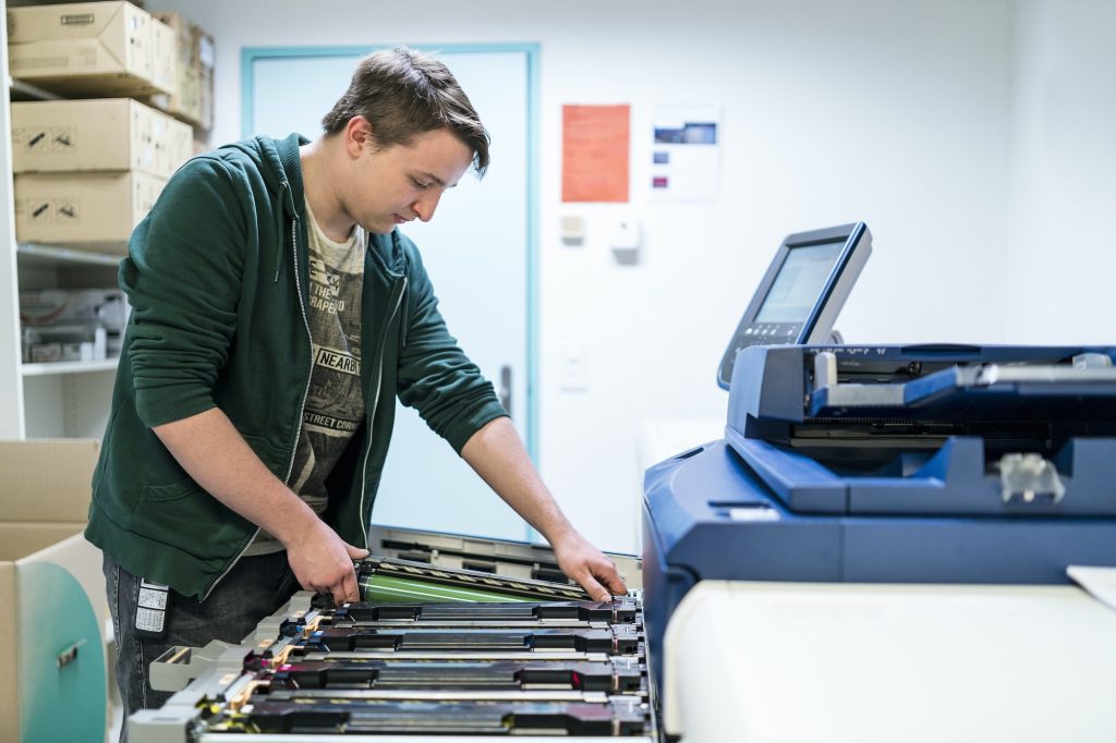 Teenager working at color printer