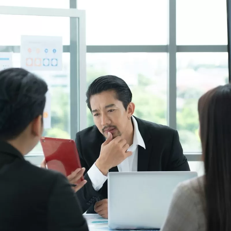 A group of young Asian entrepreneurs. Top Management is meeting to review stock investment data