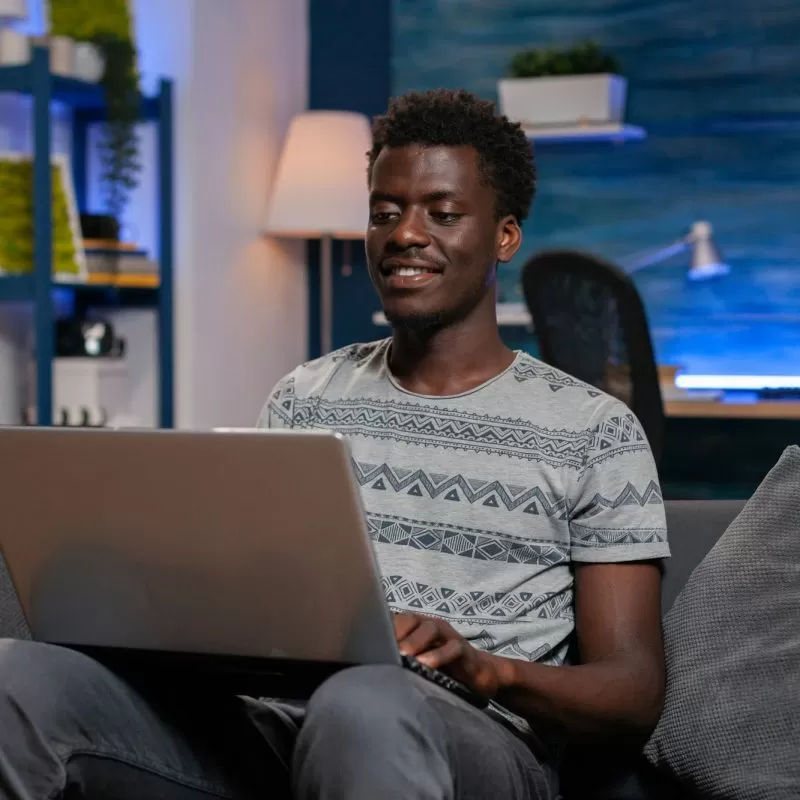 African american employee sitting on couch browsing communication information