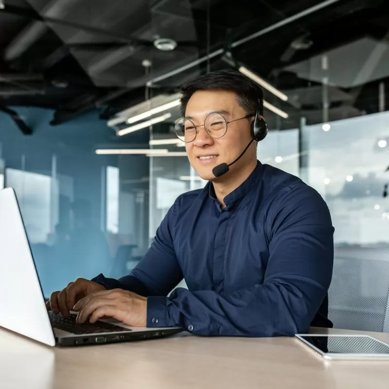 Happy and smiling worker with headset for video call, Asian tech support man talking to online